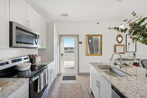 A kitchen with granite countertops and stainless steel appliances.