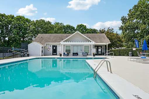 A swimming pool in front of a house.