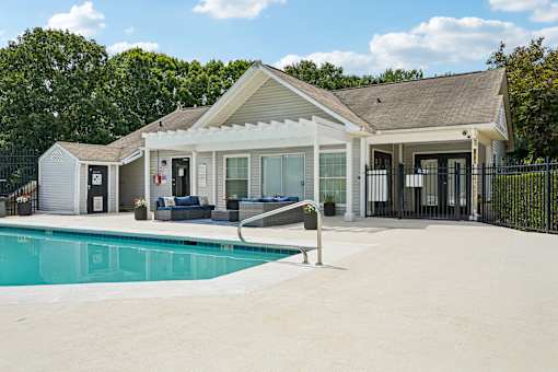 A house with a pool in front of it.