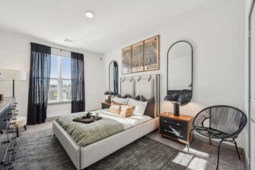 A bedroom with a large bed and a chair.