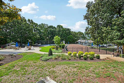 A park with a playground and a tennis court.