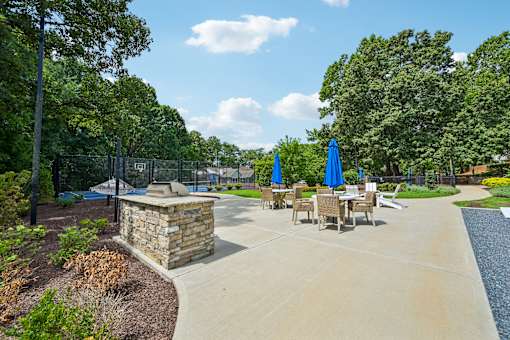 A sunny day at the park with a stone structure and tables set up for outdoor dining.