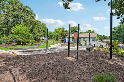 A playground with a swing set and a building in the background.