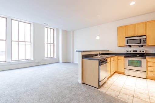a kitchen with a stove top oven next to a window at 26 West, Managed by Buckingham Urban Living, Indianapolis