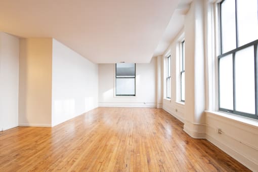 an empty room with hardwood floors and large windows at 26 West, Managed by Buckingham Urban Living, Indianapolis