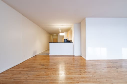 an empty living room with white walls and wood floors at 26 West, Managed by Buckingham Urban Living, Indianapolis