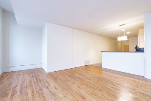an empty living room with white walls and wood floors at 26 West, Managed by Buckingham Urban Living, Indianapolis