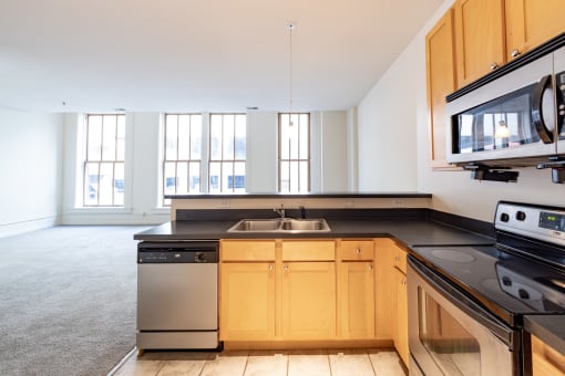 a kitchen with black countertops and white walls at 26 West, Managed by Buckingham Urban Living, Indianapolis