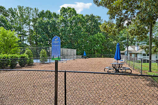 A baseball field with a blue sign and a picnic table.