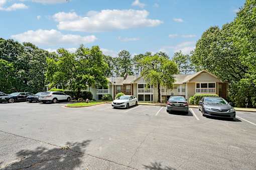 A parking lot with cars and a building in the background.