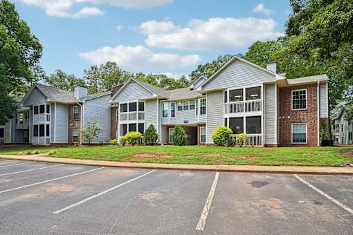 A row of houses with a parking lot in front.