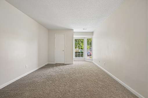 A room with a carpeted floor and a sliding glass door.