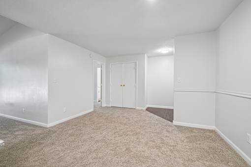 A room with white walls and carpeted floor.