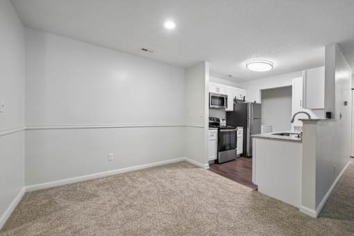 A kitchen with white appliances and a white island.