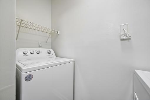 A white dryer is sitting in a laundry room.