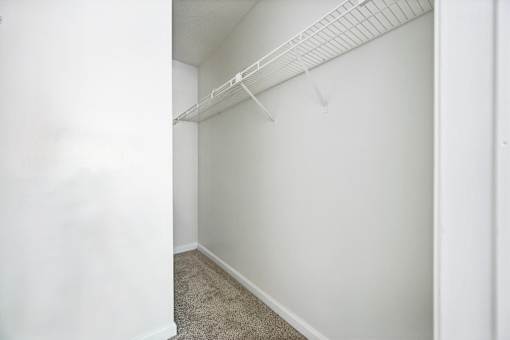 A white wall with a white shelf above it.
