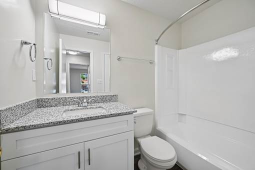 A bathroom with a sink, toilet, and bathtub.