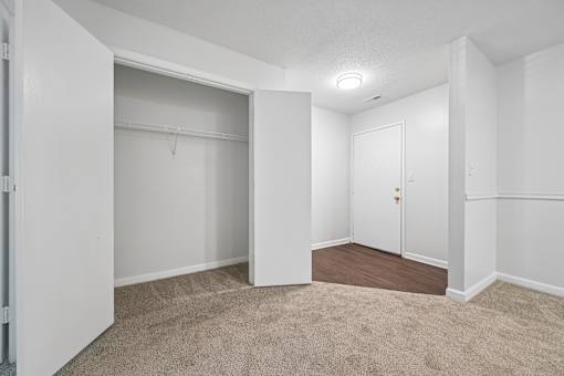 A white room with a carpeted floor and a door.