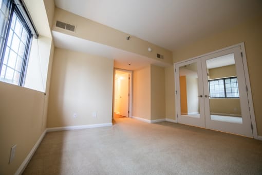 the living room of an empty house with a door to a hallway at The Ambassador at Library Square, Indianapolis, 46204