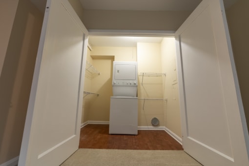 a small laundry room with a washer and dryer in it at The Ambassador at Library Square, Indianapolis, IN, 46204