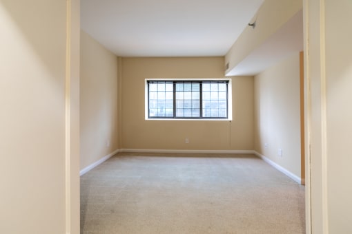 an empty living room with a window in it at The Ambassador at Library Square, Indianapolis, Indiana