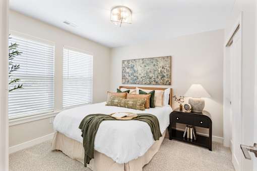 A bedroom with a large bed and a painting on the wall.