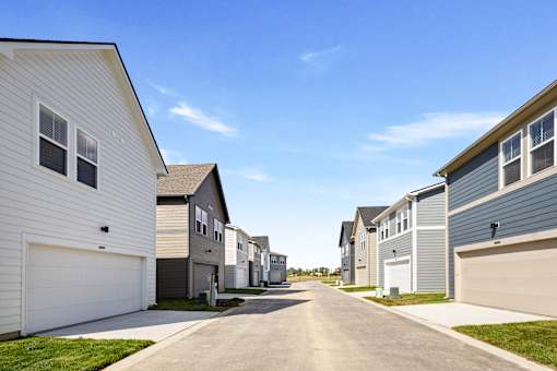 A row of houses with garages on the side.