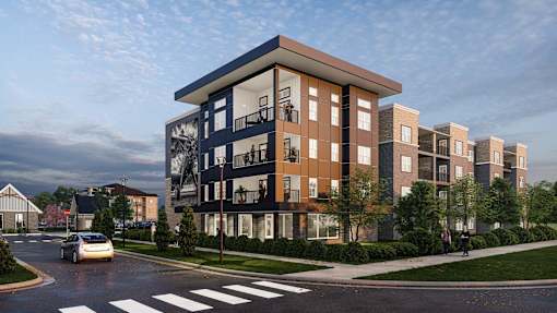 A modern apartment building with a car driving on the street in front.