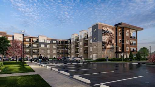 A large apartment complex with a parking lot in front.