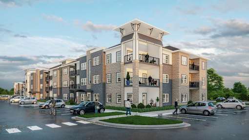 A modern apartment complex with cars parked in front.