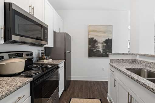 A kitchen with a painting on the wall.
