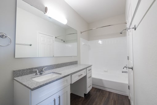 Renovated bathroom featuring granite counters at Center Point Apartments, Indianapolis