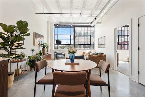 Loft dining table and living area beneath exposed white beams