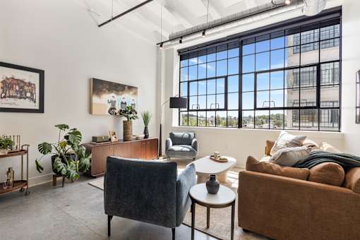 Living room with credenza, sectional and twelve-foot ceilings in a Cole Motor loft