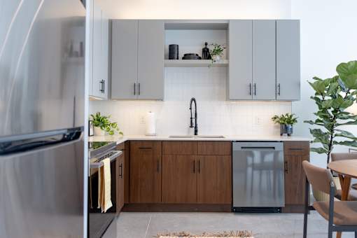 Loft kitchen with walnut lower cabinets, gray uppers and quartz countertops