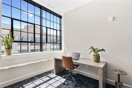 Co-working office desk beneath an original steel factory window