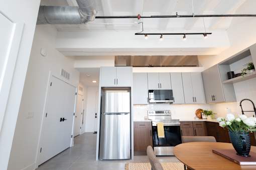 Loft kitchen with exposed timber ceiling and entry hall beyond