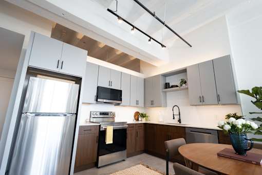 Loft kitchen beneath an original exposed beam ceiling and track lighting