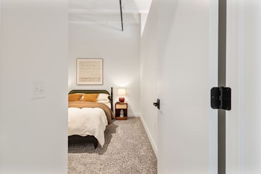 View through an open bedroom door to the bed beyond