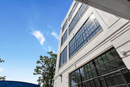 Historic steel factory windows and white painted brick on the Cole Motor facade