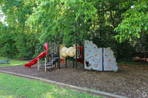 a playground with a slide and other toys in a park at Elea Apartments in Marietta, GA