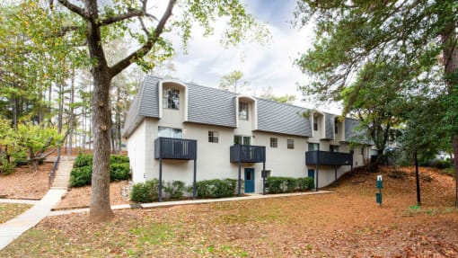 a white house with trees and a sidewalk at Elea Apartments in Marietta, GA
