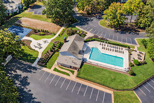 A large building with a pool in the middle of a grassy area.