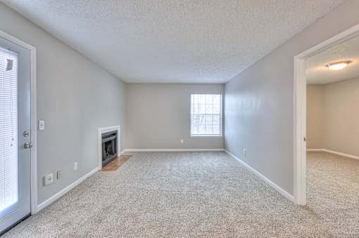 A spacious room with a fireplace and a window at Landmark at Lyncrest Reserve Apartments, Nashville