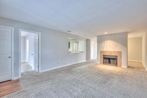 A spacious living room with a fireplace and a carpeted floor at Landmark at Lyncrest Reserve Apartments, Tennessee 37209