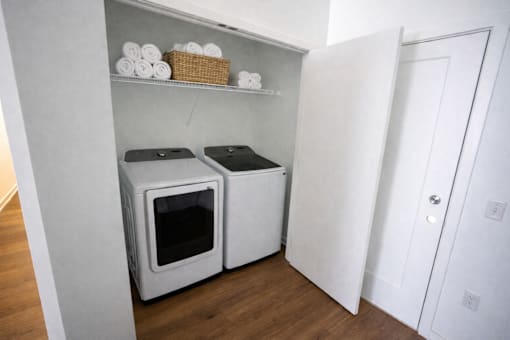 A white cabinet with two ovens and a basket on top.