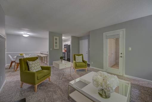 A living room with a green chair and a white coffee table.