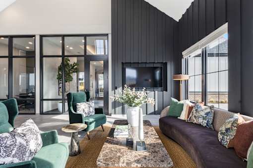 A living room with a green couch, a brown sofa, and a TV.