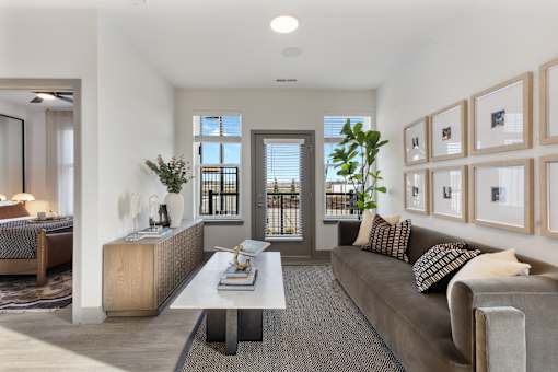 Bright model apartment living room at Montage featuring modern furnishings, natural light, and balcony accessw.