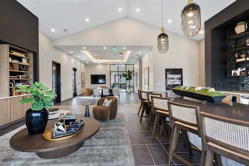Spacious resident lounge at Montage featuring built-in shelving, mounted TV, plush seating, and open-concept gathering and dining areas